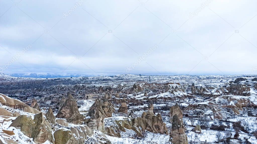 Fairy Chimneys at the valley covered with snow in winter in Goreme, Cappadocia, Turkey