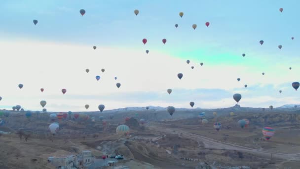 Türkiye 'nin Kapadokya kentindeki vadi üzerinde uçan sıcak hava balonlarının hava manzarası — Stok video