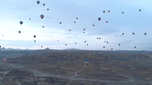 Türkiye 'nin Kapadokya kentindeki vadi üzerinde uçan sıcak hava balonlarının hava manzarası — Stok video