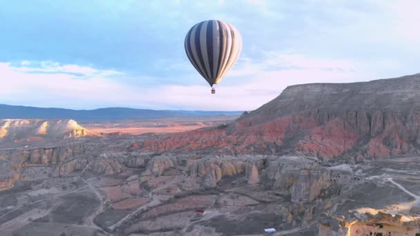 一人で熱気球がトルコのカッパドキアのテッドバレーを飛んでいます — ストック動画