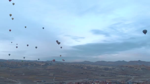 Luchtfoto van heteluchtballonnen die over de vallei vliegen in Cappadocië, Turkije — Stockvideo