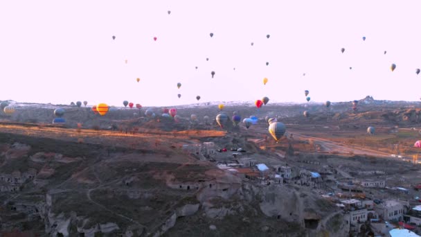 Paisaje del valle aéreo con muchos globos de aire caliente en el cielo azul claro al amanecer en Capadocia, Turquía — Vídeos de Stock