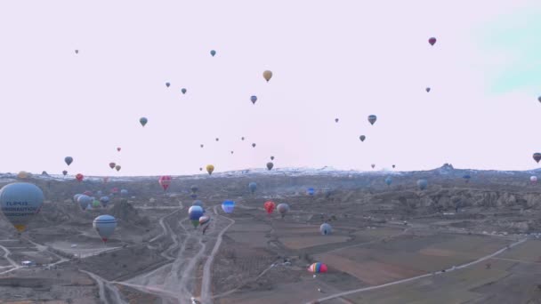 Paisaje del valle aéreo con muchos globos de aire caliente en el cielo azul claro al amanecer en Capadocia, Turquía — Vídeo de stock