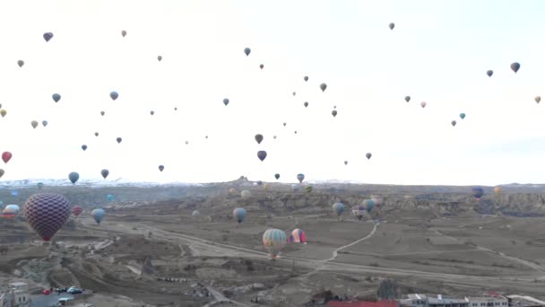 Paisaje del valle aéreo con muchos globos de aire caliente en el cielo azul claro al amanecer en Capadocia, Turquía — Vídeo de stock