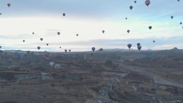 Aerial valley landscape with lots of hot air balloons at the clear blue sky at sunrise in Cappadocia, Turkey — Stock Video