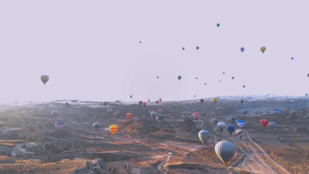 Paesaggio della valle aerea con un sacco di mongolfiere al cielo blu chiaro all'alba in Cappadocia, Turchia — Video Stock