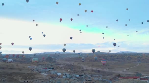 Paisaje del valle aéreo con muchos globos de aire caliente en el cielo azul claro al amanecer en Capadocia, Turquía — Vídeo de stock