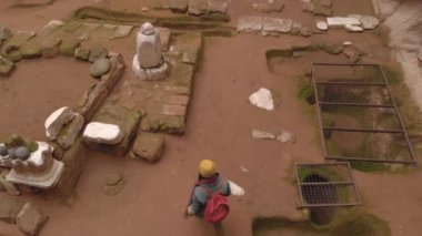 Gumusler mağara manastırında yalnız yürüyen bir kadın. Kapadokya, Türkiye 'de taş duvarlarla çevrili antik mağara manastırında yürüyen bir kız
