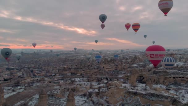 土耳其卡帕多西亚冬季日出时分 五彩缤纷的热空气在雪白的红色山谷上盘旋着仙女的烟囱 — 图库视频影像