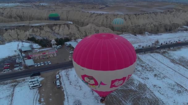Mongolfiera Solitaria Che Vola Bassa Nel Paesaggio Innevato Della Cappadocia — Video Stock