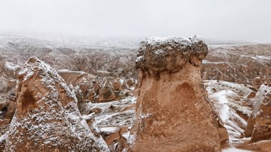 Kapadokya 'daki Devrent Valley' de karlı manzaralı peri bacaları. Cappadocia 'da kış mevsiminde Hayali Vadi' de eşsiz kaya oluşumları.