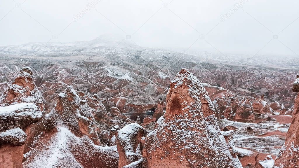 Fairy chimneys with snowy landscape at Devrent Valley in Cappadocia. Unique rock formations in Imaginary Valley in winter season in Cappadocia.