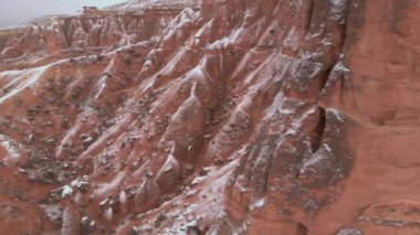 Kapadokya 'daki Devrent Valley' deki karlı manzaranın sinematik hava görüntüsü. Kapadokya 'da kış mevsiminde eşsiz Tuff Rock oluşumlarıyla dolu hayali vadide kar tarafından çevrelenmiş peri bacaları.. 