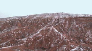 Türkiye 'nin başkenti Kapadokya' da kış mevsiminde, Devrent Vadisi 'nde veya hayal gücü vadisinde tuff oluşumlarıyla çevrili seyahat eden çiftlerin hava karlı vadisi manzarası