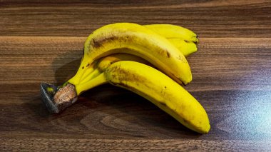 Olgun sarı muz sürüsü ahşap arka planda kapanıyor.. 