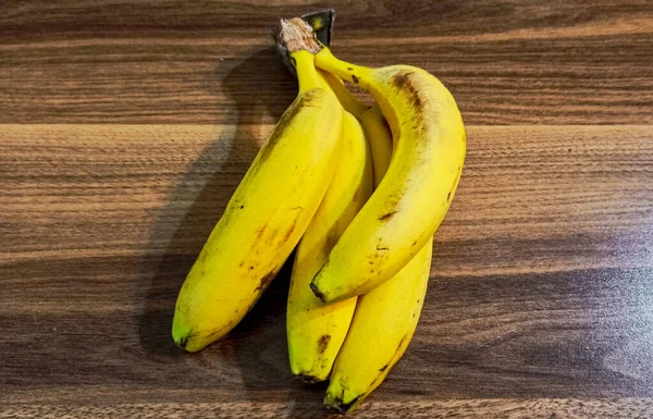 Ramo Plátanos Amarillos Maduros Cerca Sobre Fondo Madera — Foto de Stock