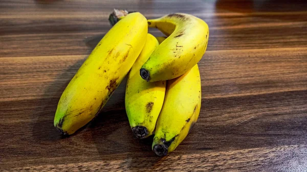 Ramo Plátanos Amarillos Maduros Cerca Sobre Fondo Madera — Foto de Stock