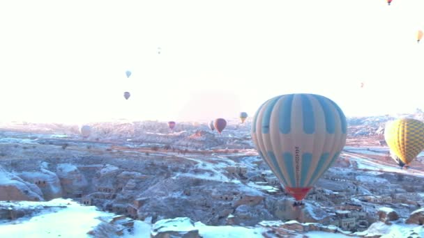 Letecký Pohled Horkovzdušné Balóny Letící Nad Starobylými Jeskynními Domy Zasněženou — Stock video