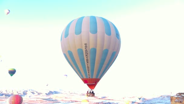 Luchtfoto Van Heteluchtballonnen Die Oude Grotwoningen Vliegen Met Besneeuwd Vulkanisch — Stockvideo