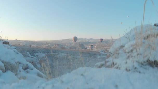 Luchtfoto Van Heteluchtballonnen Die Oude Grotwoningen Vliegen Met Besneeuwd Vulkanisch — Stockvideo