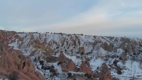 雪の空中映画のビューは カッパドキア トルコの火山岩の形成でレッドバレーをカバー — ストック動画