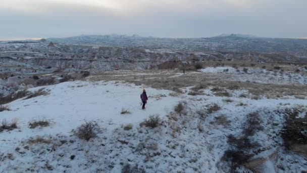 在土耳其的卡帕多西亚 一对可爱的旅行夫妇在雪地上漫步的美丽的空中风景覆盖了红谷 形成了壮观的火山岩 — 图库视频影像