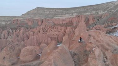 Türkiye 'nin başkenti Kapadokya' da kar altındaki volkanik arazide motosiklet sürüşünün hava takibi