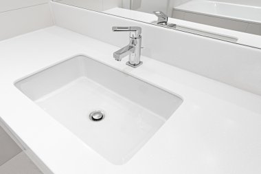 Beyaz ayna tarafından lavabo.