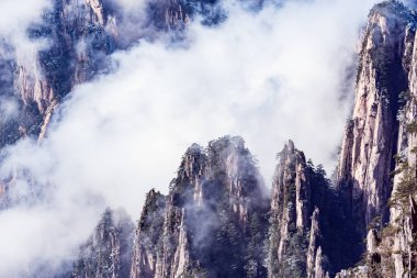 Huangshan Ulusal Parkı 'nın tepelerinde bulutlar var..