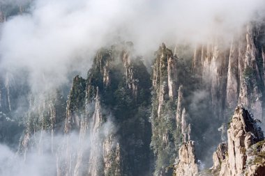 Huangshan Ulusal Parkı 'nın tepelerinde bulutlar var..