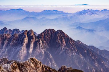 Huangshan Ulusal Parkı 'nın tepelerinde bulutlar var..
