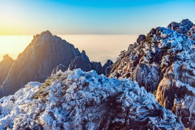 Sunrise yukarıda renkli doruklarına Huangshan Milli Parkı.
