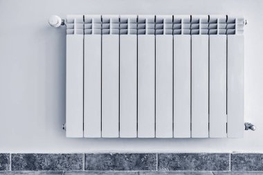 Koridorda beyaz radyatör.