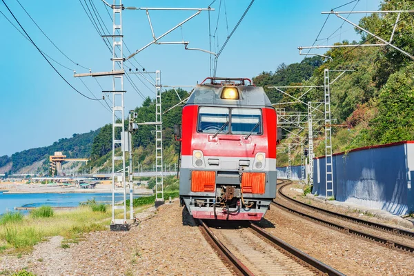 Tren de pasajeros se mueve a lo largo de las montañas y el mar Negro . — Foto de Stock
