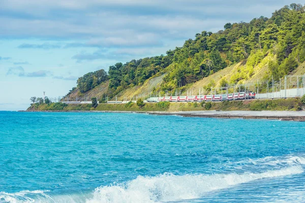 Passagerare dubbel däck tåg rör sig längs Svarta havet stranden. Sotji. Ryssland. — Stockfoto