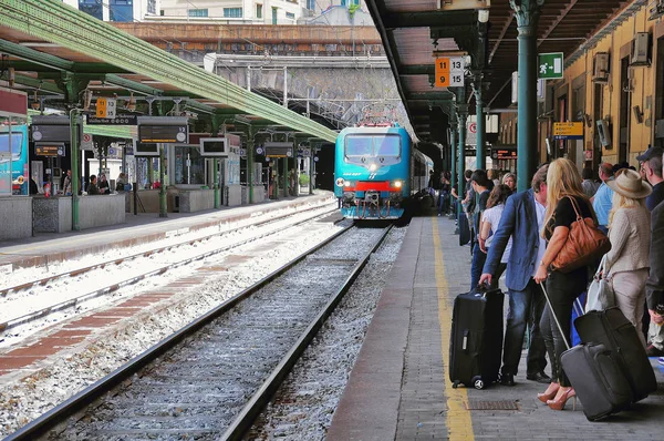 O trem de passageiros se aproxima da plataforma de multidões durante o dia . — Fotografia de Stock