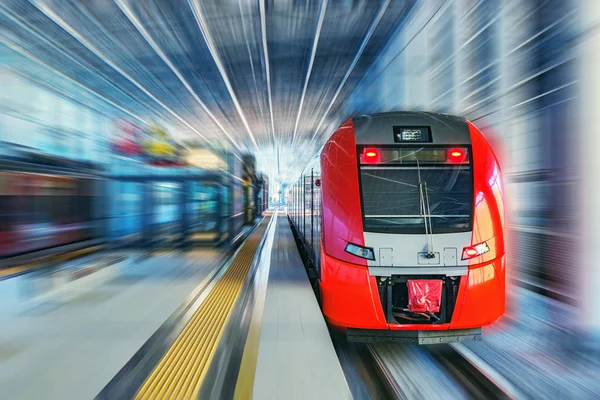 Tren de alta velocidad de pasajeros se mueve rápido a lo largo de la plataforma de la estación de tren . —  Fotos de Stock