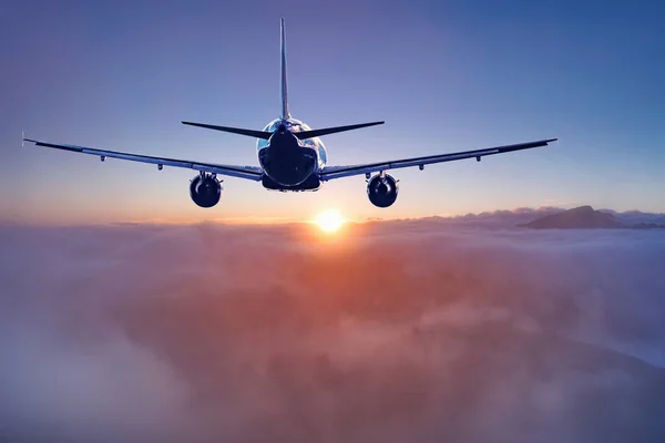 Lot samolotu pasażerskiego nad chmurami i górami. — Zdjęcie stockowe