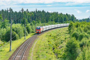 Yolcu treni yaz sabahı istasyona yaklaşıyor.
