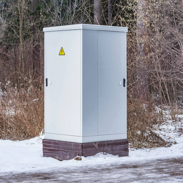 Metal electric cabinet in the forest in the snowdrift.