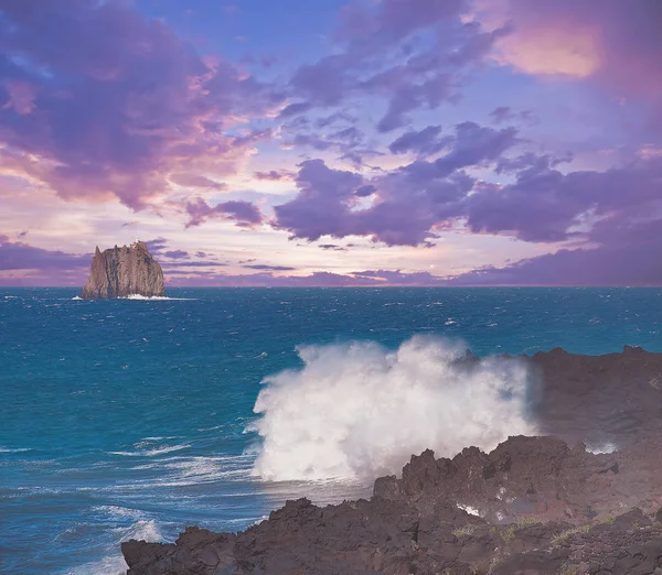 Vågor vid vulkaniska klippor vid solnedgången. — Stockfoto