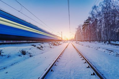 Yüksek hızlı tren kış günbatımında hızlı hareket eder..