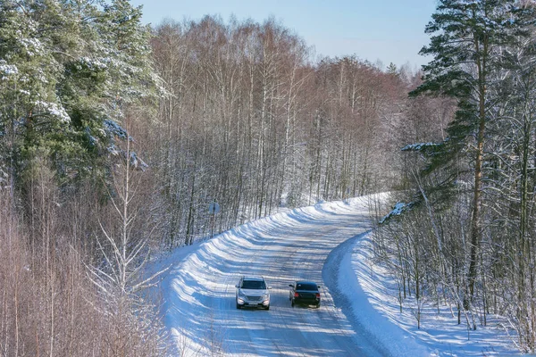 Машины на дороге в зимнем лесу . — стоковое фото