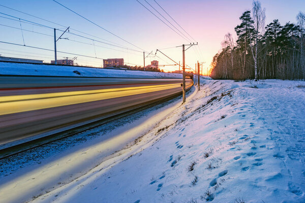Высокоскоростной поезд быстро движется в зимнее время заката
.