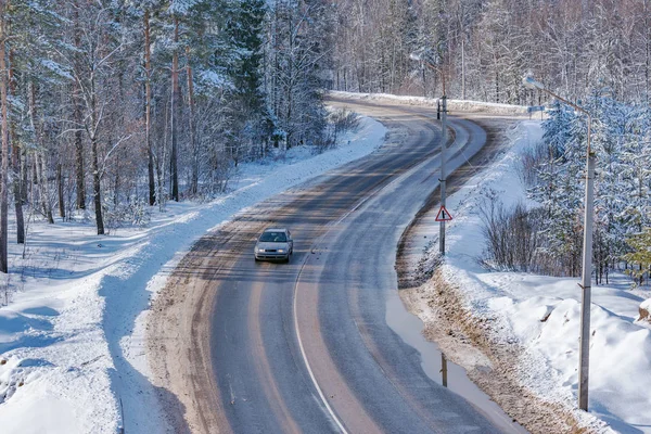 Car on the road in the winter forest.