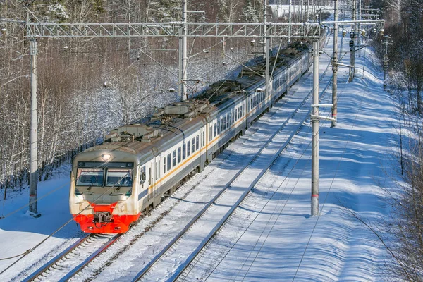 O trem de passageiros se aproxima da estação no horário da manhã de inverno . — Fotografia de Stock