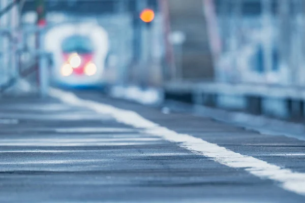 Imagen borrosa del tren de alta velocidad que se aproxima a la plataforma de la estación al atardecer . — Foto de Stock