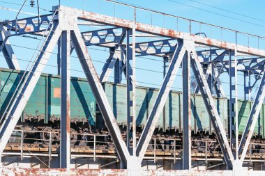 Yük treni metal köprüde hareket ediyor..