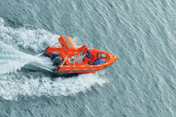 Salvavidas en chaquetas naranjas en el barco . — Foto de Stock