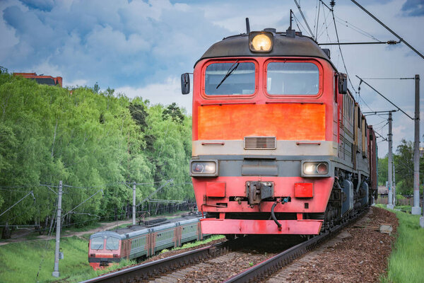 Грузовой поезд движется по весеннему лесу
.